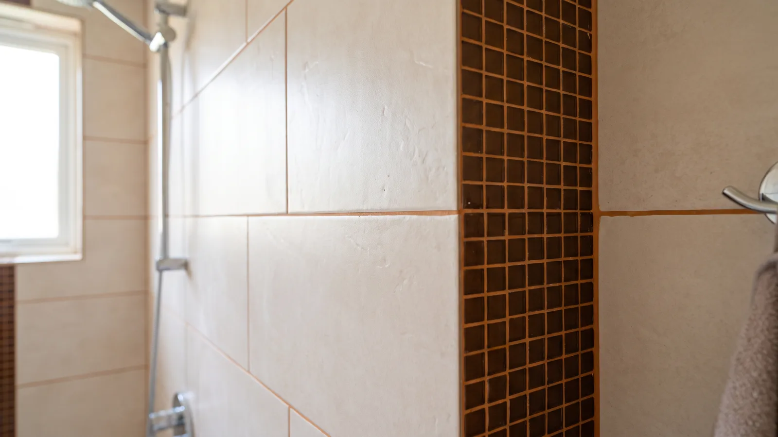 Eine moderne Fliesen Badezimmer Wand mit hellen und dunklen Mosaikfliesen in einem Bad.